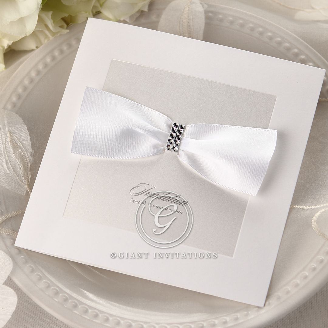 Lightly textured card printed in calligraphic raised ink lettering, attached to a gorgeous card with silk screened front cover, adorned with a white bow and gems
